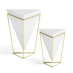 two white vases with gold trim on each side and one in the shape of a triangle