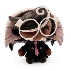 a small stuffed animal with glasses and a tie on it's head, sitting next to a white background