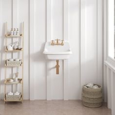 a white sink sitting next to a wooden shelf filled with cups and saucers in a bathroom