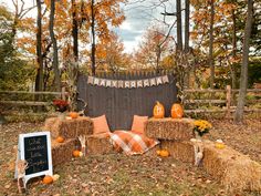 hay bales and pumpkins are arranged on the ground