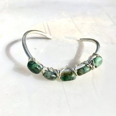 Thank you for looking at this very special handmade wire wrapped cuff bracelet. This is my unique original design created with solid sterling silver and gemstones. This cuff has a natural untreated emeralds I can only make 2 of these right now The cuff weight is approximately 19 grams. Please allow for minor differences as each cuff is handmade and created for you. The sterling is 925, solid,Tested guaranteed, purchased from my sterling silver provider. measure your wrist with a string, to a ruler, the small of your wrist, if you use a tape measure, make sure its a soft one or use a string. The cuffs are slightly adjustable western, southwestern, luxury, Christmas, Gift, May birthstone Artisan Adjustable Wire Wrapped Cuff Bracelet, Bohemian Sterling Silver Wire Wrapped Bracelets, Artisan Wire Wrapped Bangle Cuff Bracelet, Adjustable Sterling Silver Cuff Bracelet Hand Wrapped, Adjustable Sterling Silver Hand Wrapped Cuff Bracelet, Adjustable Hand Wrapped Sterling Silver Cuff Bracelet, Luxury Christmas, Handmade Wire Wrapped, Green Gems