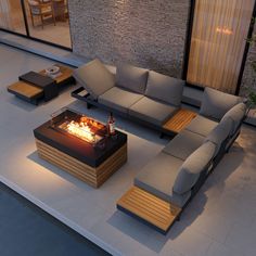 an outdoor living room with a fire pit and couches on the floor next to it