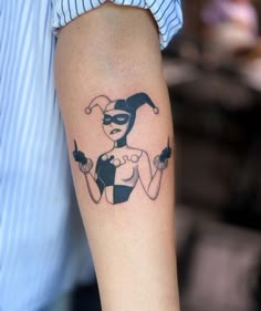 a woman's arm with a tattoo on it that has an image of a female joker