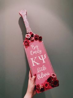 a person holding up a pink sign with flowers on it that says, big empty key to little california