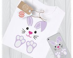 a white shirt with an image of a rabbit on it and a cell phone next to it