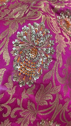 an intricately designed purple and gold brocaded fabric with orange, silver, and green accents