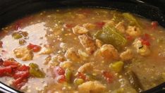 a black crock pot filled with soup and vegetables