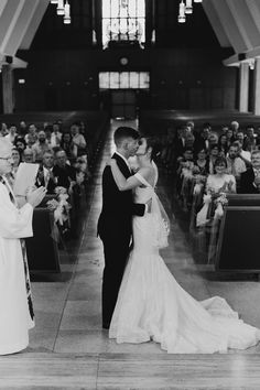 a bride and groom kissing in front of an audience