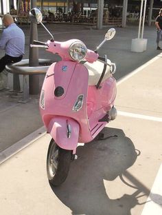 a pink scooter is parked on the sidewalk