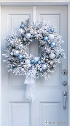 a christmas wreath on the front door with ornaments hanging from it's sides and snowflakes