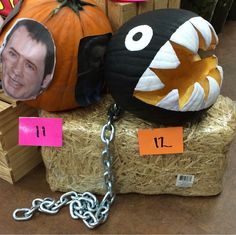 two pumpkins that have been placed on top of hay with chains attached to them