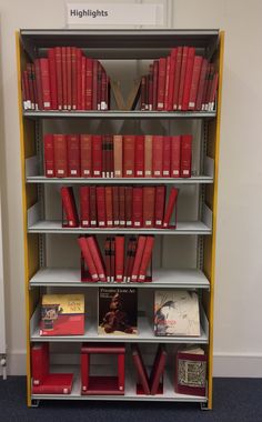 a book shelf filled with lots of red books