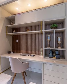 a white desk topped with a laptop computer next to a book shelf filled with books