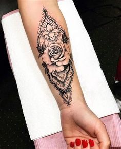 a woman's arm with a rose tattoo on it