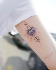 a woman's arm with a tattoo on it that has an image of a star and moon