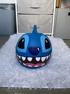 a blue ball sitting on top of a white rug next to two storage bins