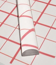 a roll of tape sitting on top of a piece of paper with red and white squares