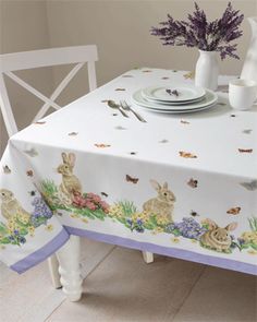 the table cloth has rabbits and flowers on it