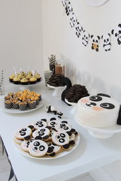 a table topped with lots of cakes and desserts covered in frosting panda bears