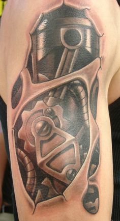 a man's arm with a tattoo on it that has an image of a motorcycle engine