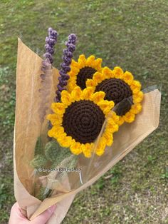 a hand holding a bouquet of sunflowers and lavender