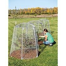 a woman kneeling down in front of a metal cage with plants growing out of it