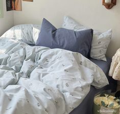 an unmade bed with blue and white sheets