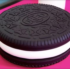 an oreo cookie sitting on top of a pink table