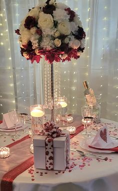 a table set up for a valentine's day dinner with candles and flowers on it