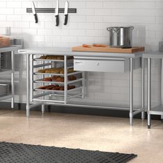 an industrial kitchen with stainless steel appliances and white tile walls, including trays for donuts