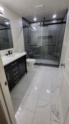 a bathroom with marble floors and black cabinets