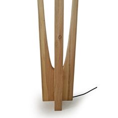 a wooden table lamp that is on top of a white surface with a black cord attached to it