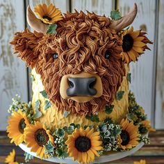 a cake decorated with sunflowers and a cow's head on top of it