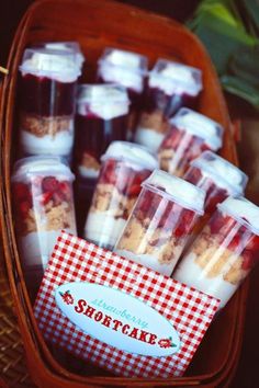 there are many desserts in plastic cups on the table with a sign that says shortcake