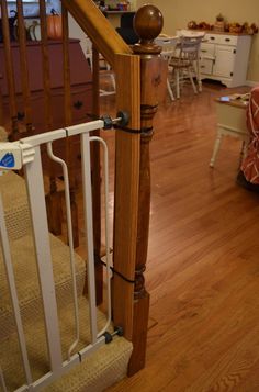 a wooden stair rail in the middle of a room with wood flooring and white railings