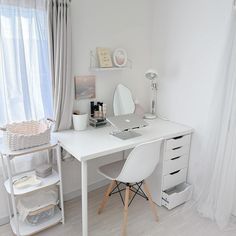 a white desk with a laptop computer on top of it in front of a window