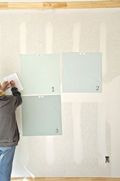 a woman standing in front of a wall with some paint on it