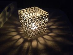 a lit candle sitting on top of a table next to a black and white object