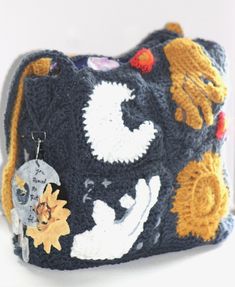 The 'Dream Land Love' navy blue granny square crochet purse depicts the time spent between Agent Night and Agent Daybright from Crescent City: House of Sky and Breath. The optional keychain for this bag represents one of our favorite scenes between these two characters. Bag Description: The upper left granny square is a moon inspired by Agent Night's space/ galaxy persona. On the lower right square is a sun inspired by Agent Daybright's flame/sun-like appearance. The lower left and top right squares portray how Ruhn kept reaching out and trying to get closer to Agent Daybright. As such each of these squares has a hand reaching for the other. It also pairs great with our "You Remind Me That I'm Alive" quote-inspired keychain. The inside of the bag is lined with galaxy fabric. Bag Measuremen Granny Square Crochet Purse, House Of Sky And Breath, Sky And Breath, Galaxy Fabric, Hope Strength, Dream Land, Space Galaxy, Crochet Purse, Square Crochet