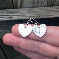 Simply Bold introduces to you these sterling silver hammered heart dangles that are a great staple piece to have. They are simple to be dressed down, but also elegant to be dressed up! These earrings are hand hammered to give the faceted look. They are then polished to a high shine and the facets glitter with every move. Each heart is hand pierce from thick 20 gauge Sterling Silver, and hung on french hook sterling silver earring backs. These earrings are made to order.Materials: Sterling Silver Jewelry Silver Earrings, Sterling Silver Heart Earrings, Hand Piercing, Silver Heart Earrings, Earrings Heart, Love Jewelry, Silver Earrings Handmade, Heart Dangle Earrings, Statement Ring Silver