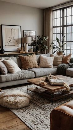 a living room filled with lots of furniture and large windows in the wall behind it