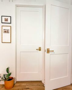 two white doors in a room with wood floors