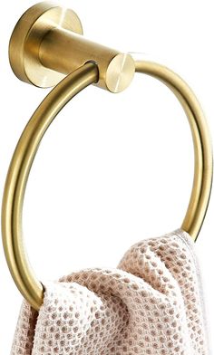 a gold colored towel ring with two white towels hanging from it's end,