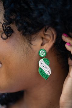 Introducing our Marjorie earring! Perfect for the AKA women out there, the Marjorie earring features a green, pink and pearl beaded design and will add a fun statement to any outfit! This earring measures 1.5". Each earring features soft, acrylic felt backing. Designed in our Creative Studio in Charleston, SC & handmade by skilled artisans. Charleston Sc, Bead Designs, Creative Studio, Pearl Beads, Charleston, Felt, Green, Pink, Design