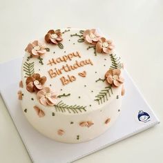 a birthday cake with white frosting and pink flowers