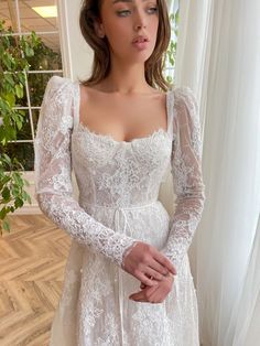 a woman wearing a white wedding dress with long sleeves