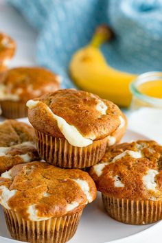 several muffins on a white plate with bananas in the backgroung