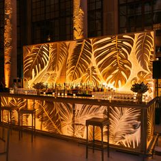 the bar is decorated with tropical leaves and lit up by candlelightes on either side