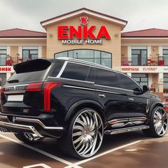 an suv parked in front of a building with the name enka mobile home on it