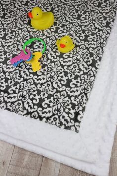 three rubber ducks on a black and white blanket